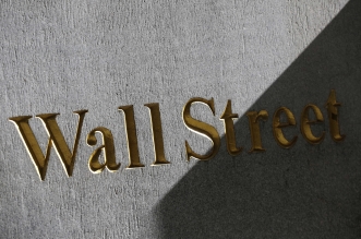 FILE - This March 4, 2013 file photo shows a sign for Wall Street on the side of building near the New York Stock Exchange, in New York. U.S. stocks are opening lower Tuesday, Sept. 23, 2014, following disappointing economic news and U.S.-led airstrikes against Islamic State militants in Syria. (AP Photo/Mark Lennihan, File)