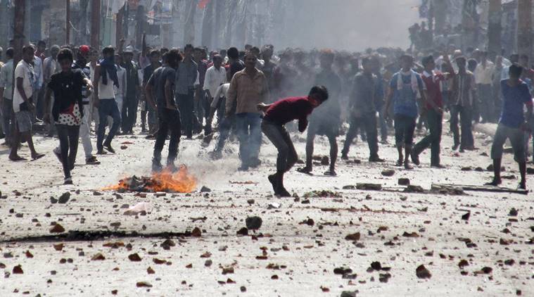 Ethnic Madhesi protesters throw stones and bricks at Nepalese policemen in Birgunj, a town on the border with India, Nepal, Monday, Nov. 2, 2015. Ethnic protesters demonstrating against the new constitution clashed with police in south Nepal Monday which left at least one person killed and several more injured, officials said. (AP Photo/Jiyalal Sah)